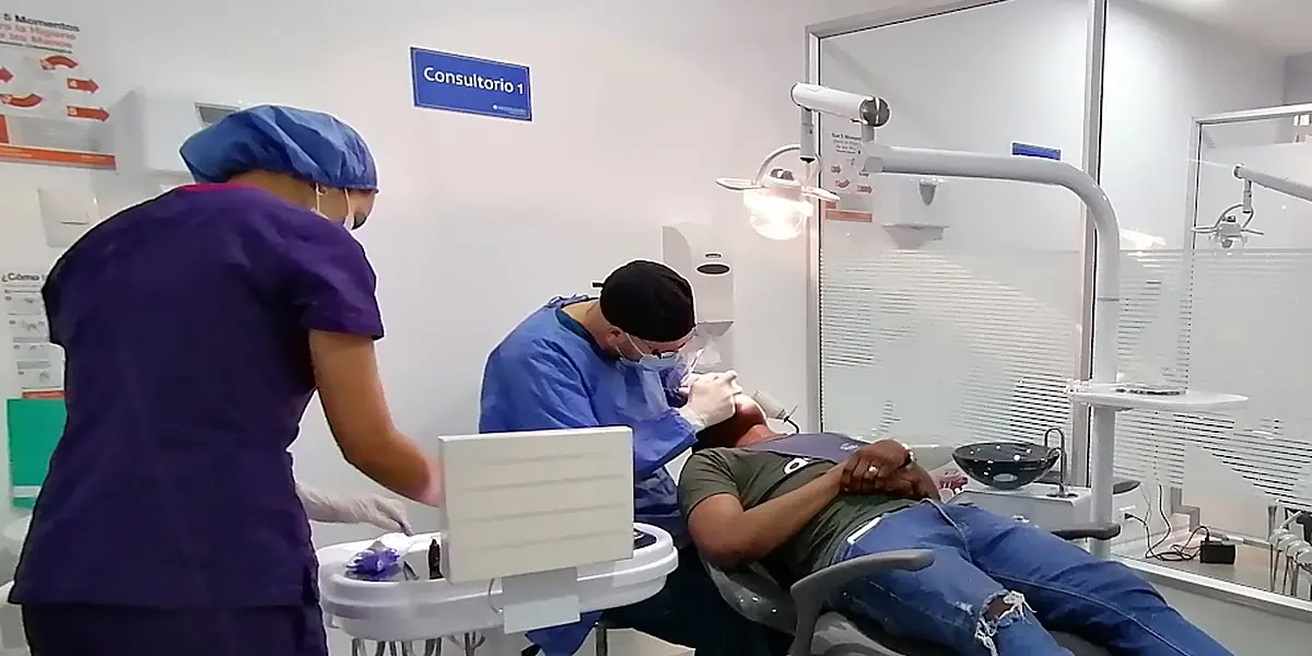Una odontóloga y su auxiliar atendiendo en consulta.